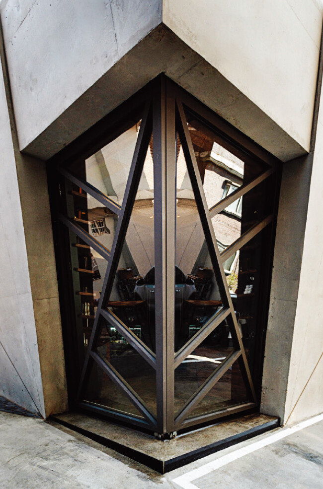 양면 여닫이 슬라이딩 도어로 된 출입구. 꼭짓점과 꼭짓점을 연결하는 기하학적 사선이 공간에 역동감을 부여한다는 건축가 문훈의 미학이 반영돼 있다. [홍태식]