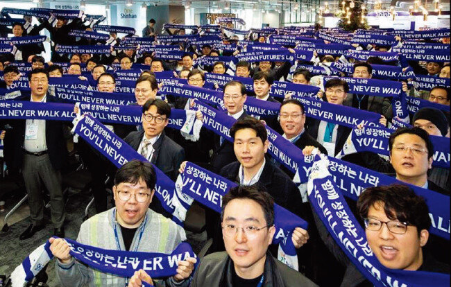 4월 11일 신한퓨쳐스랩 제2 출범식에 함께한 최종구 금융위원장과 조용병 신한금융그룹 회장, 그리고 스타트업 임직원들이 신한퓨쳐스랩의 새 슬로건인 ‘You never walk alone’이 적힌 머플러를 들고 세리머니를 하고 있다. [사진 제공 · 신한퓨쳐스랩]