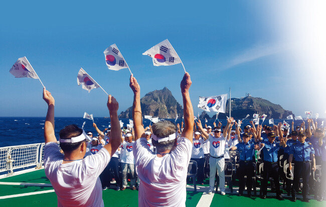 독도를 배경으로  해경훈련함 ‘바다로함’의 갑판에서 치른 제74주년 광복절 행사. 독립유공자 가족을 포함해 이 행사에 함께한 사람들이 만세 삼창을 외치고 있다. [이정훈 기자]
