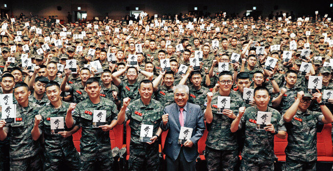 김태성 해병 제1사단장과 이국노 한국예도문화 장학체육재단 이사장(가운데)이 특강을 마친 뒤 해병대원들에 둘러싸여 기념촬영을 하고 있다. [박해윤 기자]