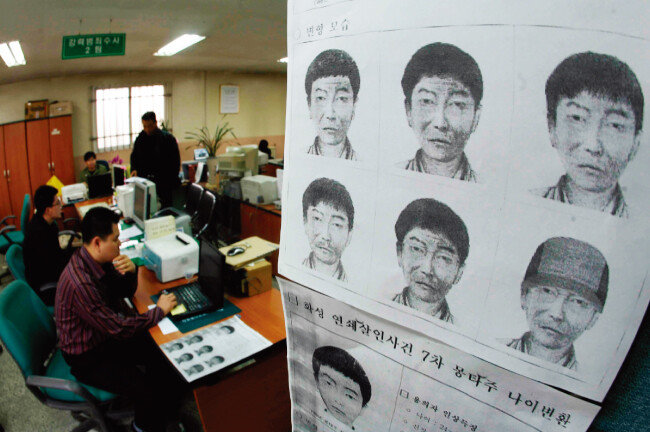 ‘화성 연쇄살인’ 사건 공소시효 만료를 앞둔 2006년 4월 2일 경기 오산시 화성경찰서 강력반 직원들이 범인 몽타주를 걸어놓고 수사 업무에 집중하고 있다. [이훈구 동아일보 기자]