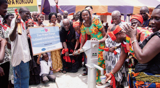 위러브유가 가나 에쿰피 스라파 코코두 마을에 기증한 물펌프에서 깨끗한 물이 쏟아지자 주민들이 기뻐하고 있다. [사진 제공 · 국제위러브유운동본부]