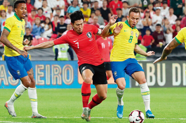 11월 19일 아랍에미리트(UAE) 모하메드 빈 자예드 스타디움에서 열린 축구 국가대표팀 평가전 대한민국과 브라질의 경기에서 손흥민(가운데)이 아르투르 멜루와 볼 다툼을 하고 있다. [뉴시스]