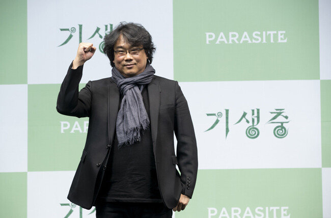 ‘기생충’ 기자회견에서 플래시 세례에 환한 미소로 답하는 봉준호 감독.[사진=박해윤 지호영 기자]