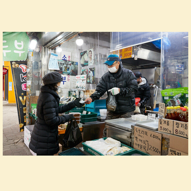 한 주부가 아침거리로 두부를 구매하고 있다. 
