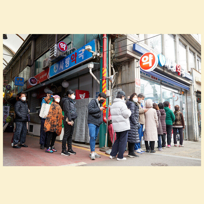이른 아침부터 공적 마스크 구매를 위해 약국 앞에 모인 사람들. 
