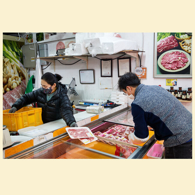 한 정육점 상인이 오늘 판매할 고기를 냉장 진열대에 넣고 있다. 