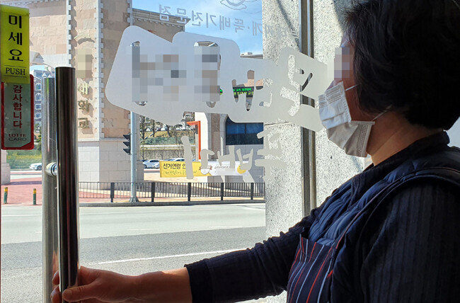 코로나19 여파로 대학들이 온라인 강의에 나선 가운데 광주 남구 한 대학교 앞 식당에서 업주가 한산한 대학 정문을 바라보고 있다. [뉴시스]