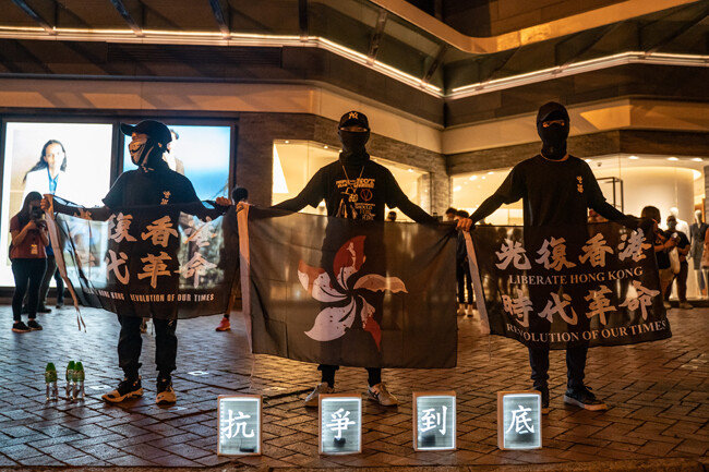 집회 도중 지난해 사망한 시위자를 추모하는 현수막을 들고 있다. [GETTYIMAGES]