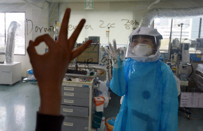 오늘도 웃으면서!경북대병원 집중치료실에서 간호사들이 환자를 돌보다가 밖에 있는 동료와 사인을 주고 받으며 웃고 있다. [뉴시스]