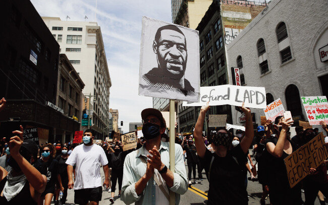 6월 2일(현지) 미국 캘리포니아주 로스앤젤레스에서 시위대가 경찰관에게 살해된 조지 플로이드의 대형사진을 들고 행진하고 있다. [뉴시스]  