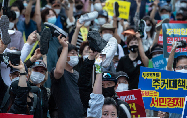 신발을 벗어들고 하늘로 향해 동시에 집어던질 준비를 하는 촛불집회 참석자들. [박해윤 기자]