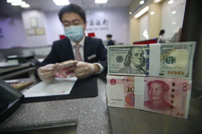 중국 은행원이 위안화를 달러화로 교환해주고 있다. [China Daily]