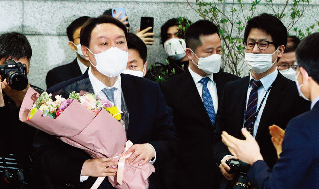 임기를 4개월여 남기고 물러나는 윤석열 검찰총장이 3월 4일 오후 직원들에게 인사한 뒤 꽃다발을 들고 대검찰청을 나서고 있다. [뉴스1]