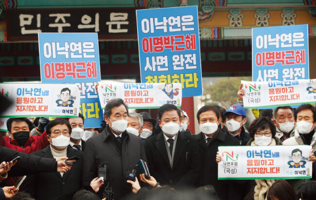 1월 18일 광주 북구 운정동 국립5·18민주묘지를 찾은 이낙연 당시 더불어민주당 대표(앞줄 왼쪽에서 두번째). 그의 뒤편에서 광주 시민단체들이 ‘이명박, 박근혜 전 대통령 사면’ 반대 시위를 하고 있다.