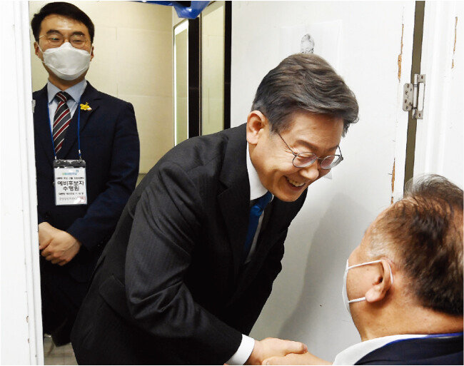 더불어민주당 대선 경선 예비후보인 이재명 경기도지사(가운데)가 7월 3일 서울 여의도 KBS에서 이상민 중앙당선거관리위원장과 악수하고 있다. 이 지사의 수행실장을 맡은 같은 당 김남국 의원이 이를 바라보고 있다. [뉴스1]