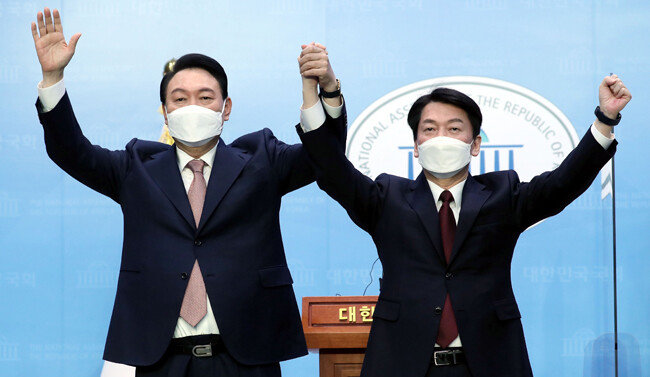 국민의힘 윤석열 대선 후보와 국민의당 안철수 대선 후보가 3월 3일 서울 여의도 국회 소통관에서 단일화 기자회견을 마친 뒤 손을 맞잡고 있다. [뉴스1]