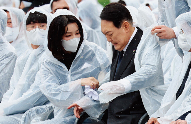 윤석열 대통령 부인 김건희 여사(왼쪽)가 6월 6일 서울 동작구 국립서울현충원에서 열린 현충일 추념식에 참석해 윤 대통령의 젖은 옷을 수건으로 닦아주고 있다. [사진 제공 · 대톨령실]