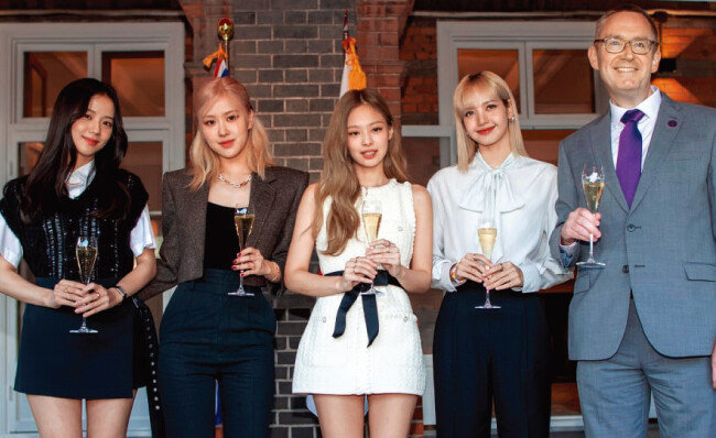 콜린 크룩스 주한 영국대사(오른쪽)와 블랙핑크가 5월 26일 서울 중구 주한 영국대사관저에서 열린 엘리자베스 2세 여왕 생신 축하연에 참석해 기념촬영을 하고 있다. [뉴시스]