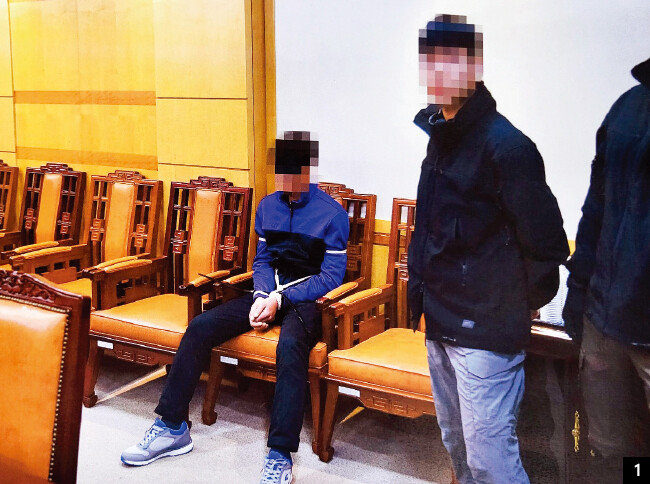 2019년 11월 7일 포승줄에 묶이고 안대를 한 탈북 어민들이 북한에 인계되기 전 판문점 남측 대기실에 앉아 있다. [사진 제공 · 통일부]