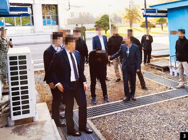 먼저 건물 밖으로 나가 송환을 위해 군사분계선 앞에 선 A 씨가 고개를 떨군 채 얼굴을 감쌌다. [사진 제공 · 통일부]