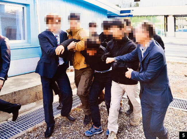 결국 A 씨는 남측 관계자 4명에게 양팔을 제압당한 채 군사분계선으로 향했다. [사진 제공 · 통일부]