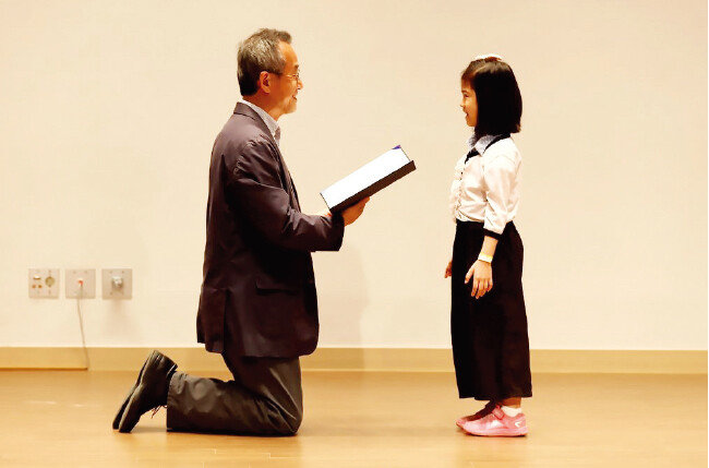 어린이에게 상장을 주면서 눈높이를 맞추고자 무릎을 꿇은 최재천 교수(왼쪽). [사진 제공 · 국립생태원]