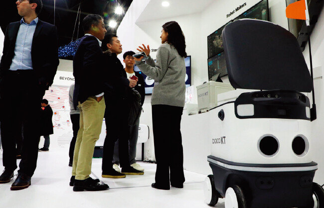 KT 부스를 찾은 관람객들이 자율주행이 가능한 실외 배송로봇(Delivery Robot)을 살펴보고 있다. [뉴스1]