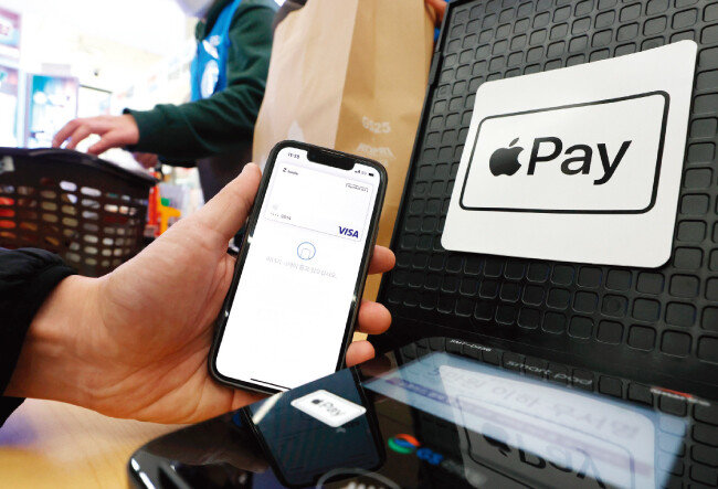 3월 21일 서울 강남구  한 편의점에서 직원이 애플 간편결제 서비스인 ‘애플페이’를 시연하고 있다. [뉴스1]