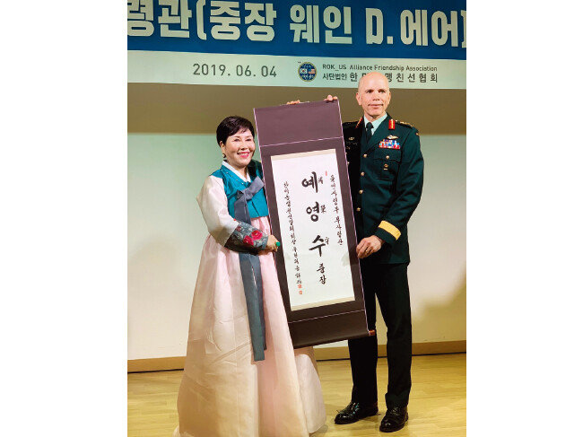 웨인 에어 당시 유엔군사령부 부사령관(오른쪽)이 2019년 6월 4일 한미동맹친선협 회로부터 ‘예영수(芮榮守)’라는 한국 이름이 적힌 족자를 선물받고 있다. 에어 장군 은 귀국 후 대장으로 진급해 2021년 캐나다군 국방참모총장에 임명됐다. [유엔군사령부 제공]