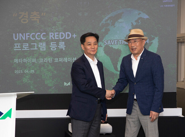 유인근 메타하이퍼 대표(왼쪽)가 4월 29일 서울 송파구 메타하이퍼 사옥에서 전주오 코라틴 코퍼레이션 대표와 UNFCCC REDD+ 프로그램 등록을 축하하며 악수하고 있다. [박해윤 기자]