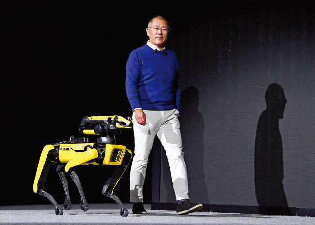 정의선 현대자동차그룹 회장이 지난해 1월 미국 라스베이거스에서 열린 ‘CES 2022’에 참석해 보스턴다이내믹스의 4족 보행 로봇 ‘스폿’과 무대에 오르고 있다. [현대차그룹 제공]