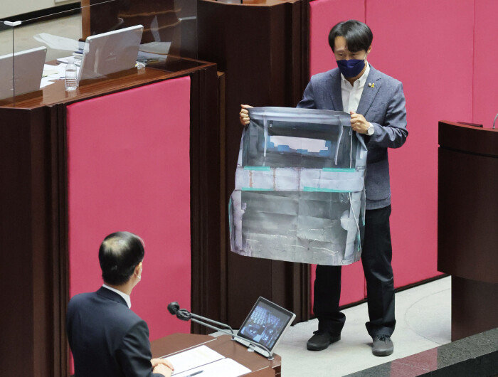 이탄희 의원이 지난해 7월 27일 서울 여의도 국회에서 열린 교육·사회·문화 분야 대정부질문에서 대우조선해양 하청 노동자 유최안 씨가 점거 농성을 펼친 철골구조물과 동일한 크기(0.3평)의 사진을 한덕수 국무총리에게 펼쳐 보이고 있다. [뉴스1]
