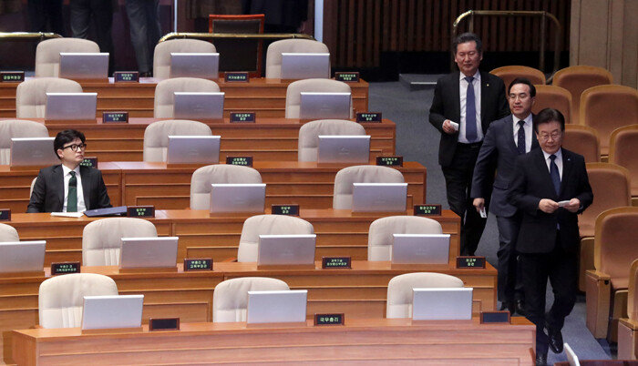 2월 27일 서울 여의도 국회 본회의장에서 이재명 더불어민주당 대표(오른쪽 첫 번째)와 정청래 최고위원(오른쪽에서 세 번째) 등이 지나가는 가운데, 한동훈 법무부 장관(왼쪽)이 착석해 있다. [김재명 동아일보 기자]