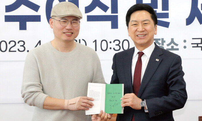 2023년 4월 3일 김기현 당시 국민의힘 대표와 곽대중 민생특위 위원이 서울 국회에서 열린 민생119 임명장 수여식 및 제1차 회의에서 곽 위원의 사인이 담긴 에세이집 ‘셔터를 올리며’를 함께 들어 보이고 있다. [뉴스1]