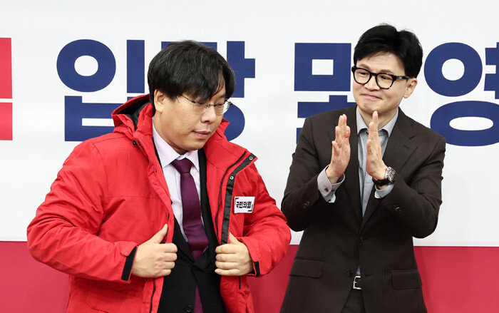 한동훈 국민의힘 비상대책위원장이 1월 8일 서울 여의도 국회에서 열린 인재영입위원회 입당 및 영입 환영식에서 박상수 변호사에게 당 점퍼를 입혀주고 있다. [뉴스1]