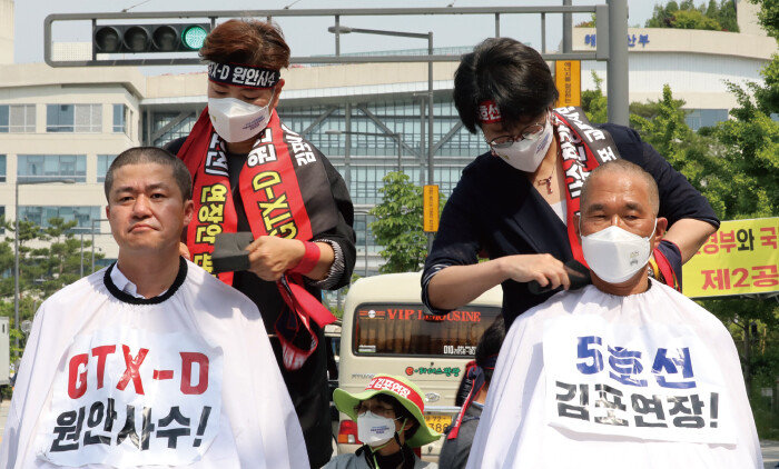 2021년 6월 2일 박상혁 더불어민주당 의원(왼쪽·김포을)과 김주영 더불어민주당 의원(김포갑)이 정부세종청사 국토교통부 앞에서 삭발 결의를 하며 ‘GTX-D노선 원안 사수 및 서울 5호선 김포 연장’을 촉구하고 있다. [뉴스1]