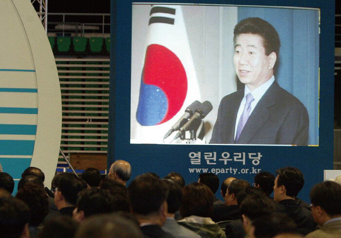 2003년 11월 11일 당시 서울 올림픽 체조경기장에서 개최된 열린우리당 창당식 도중 노무현 대통령의 축사가 대독되는 동안 노 대통령의 모습이 대형 화면에 나오고 있다. [동아DB]