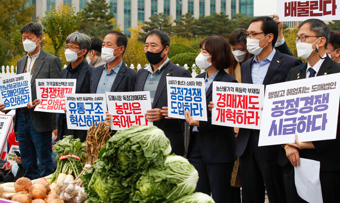 2020년 10월 21일 서울 여의도 국회 앞에서 열린 ‘가락시장 공정경쟁 도입 촉구 기자회견’에서 전국농민회총연맹, 한국소비자연맹, 한국마트협회 관계자들이 서울 송파구 가락시장 도매시장법인들의 독점적 운영을 규탄하는 시위를 하고 있다. [뉴스1]