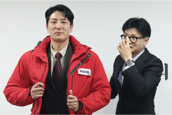한동훈 국민의힘 비상대책위원장이 2월 7일 서울 여의도 당사에서 열린 ‘국민인재 영입 환영식’에서 한정민 삼성전자 DS부문 연구원(경기 화성을 국민의힘 후보)에게 국민의힘 옷을 선물하고 있다. [뉴스1]