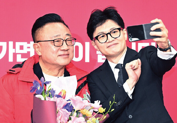 1월 22일 서울 여의도 국회에서 열린 국민인재 영입 환영식에서 한동훈 국민의힘 비상대책위원장이 갤럭시 휴대전화를 꺼내 고동진 서울 강남병 국민의힘 후보와 기념촬영을 하고 있다. [뉴스1]