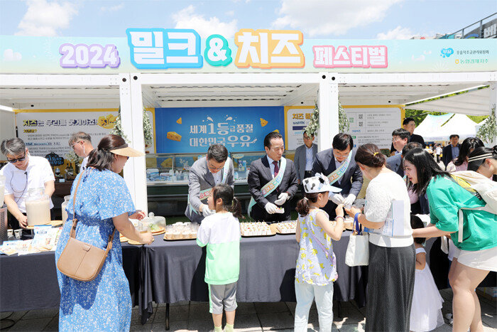 이승호 우유자조금관리위원회 위원장(가운데)과 관계자들이 국산 치즈를 관람객에게 소개하고 있다. [우유자조금관리위원회]