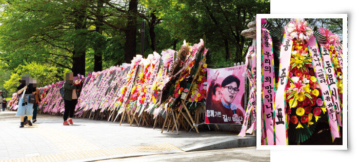 4월 17일 오후 3시쯤 서울 여의도 국회 헌정회 담벼락 앞에 국민의힘 한동훈 전 비상대책위원장을 응원하는 화환들이 세워져 있다(왼쪽). 그중 한 화환의 리본에 “질투 나서 그랬다. 내 좀 봐도! 홍준표”라고 적혀 있다. [박해윤 기자]