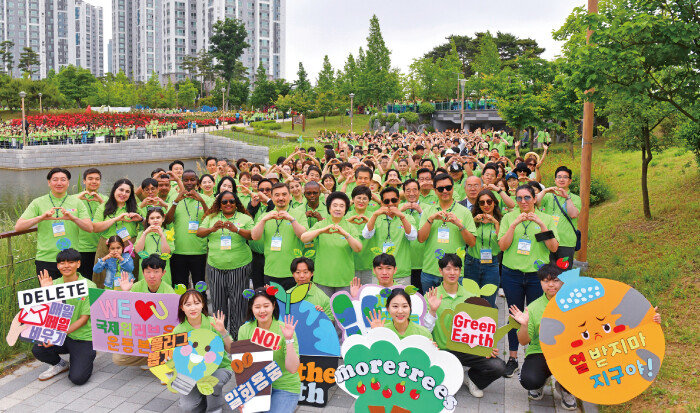 가족걷기대회 참가자들이 환경보호 실천 퍼포먼스를 선보인 위러브유 회원들과 함께 ‘지구사랑’의 의미를 담아 손하트를 하고 있다. [국제위러브유운동본부 제공]
