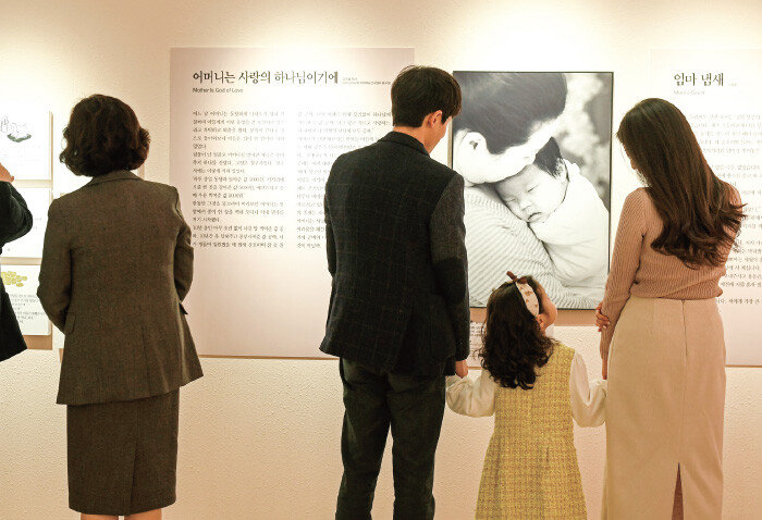 아이와 함께 전시회를 관람하는 부부. [하나님의 교회 제공]