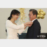 사랑의열매 홍보대사 방송인 수지 씨가 문재인 대통령에게 사랑의열매 배지를 옷깃에 달아주고 있다.