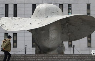 ‘A woman in a giant hat’ appears on the steps of Sejong Center