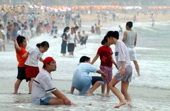 還很冷 穿著衣服洗海水浴 東亞日報