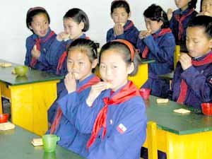 배급 비스킷으로 허기 달래는 어린이