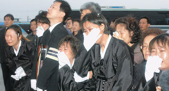 눈물로 시신 맞는 유족들